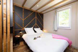 a bedroom with a large white bed and a window at Camping La Grappe Fleurie in Fleurie +105 photos