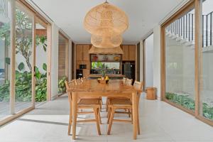 a dining room with a wooden table and chairs at Casa de Rua Villas in Badung