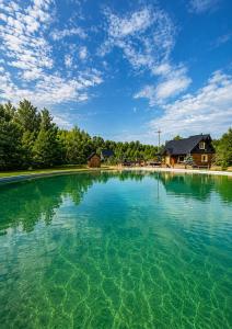 a large pool of water with a house in the background at Campo Gitano in Gaśno