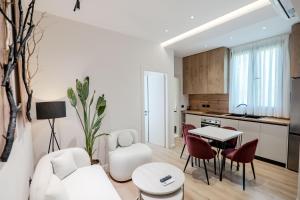 a living room with a white couch and a table at Saturn ApartHotel Tirana in Tirana