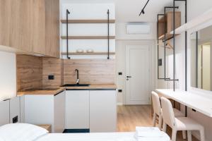 a kitchen with white cabinets and a sink at Saturn ApartHotel Tirana in Tirana +143 photos