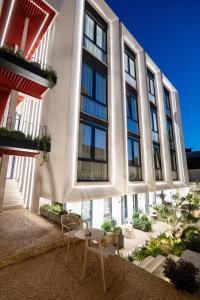 a building with a table and chairs in front of it at Saturn ApartHotel Tirana in Tirana