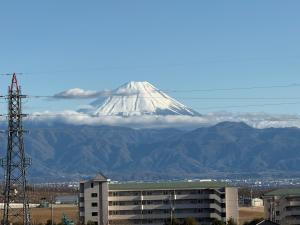 a snow covered mountain in the distance with a building at ホテル韮崎インター in Nirasaki