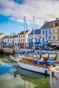 two boats are docked in a harbor with buildings at B&B HOTEL Bayeux in Bayeux