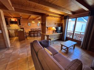 a living room with a couch and a kitchen at Appartement Chez Marion in Notre-Dame-de-Bellecombe