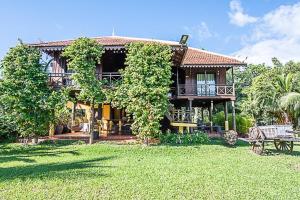 a house with a green yard in front of it at Mlis Kampot River in Kampot