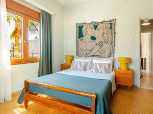 a bedroom with a bed with a picture on the wall at 4BR Newly Renovated Retreat Tranquil Coastal Haven in Hersonissos +27 photos