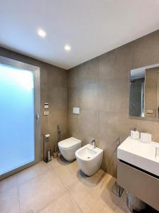 a bathroom with a toilet and a bidet and a sink at MP Luxury House in Budoni +11 photos