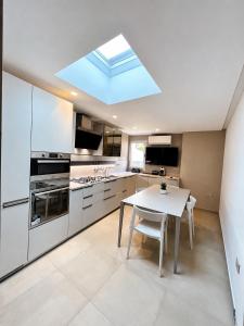 a kitchen with a white table and a skylight at MP Luxury House in Budoni