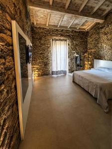 a bedroom with a bed and a stone wall at MP Luxury House in Budoni