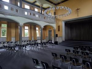 a large room with chairs and a stage in it at Ursulinenkloster in Duderstadt