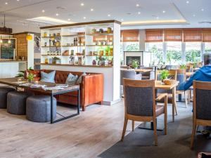 a restaurant with a table and chairs and a bar at BE BIO Hotel be active - Nähe historischer Hafen in Tönning