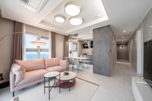 a living room with a couch and a table at Le Collective Busan Gijang in Busan