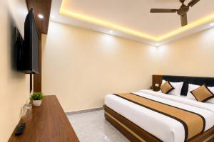 a hotel room with a bed and a television at Hotel RK Palace Vrindavan - Near Bankey Bihari and Prem Mandir in Vrindāvan