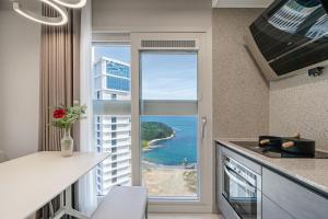 a kitchen with a window with a view of the ocean at Le Collective Busan Gijang in Busan