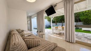 a living room with couches and a flat screen tv at Liberty spa & suites - שלוש סוויטות ושתי ווילות מהממות עם בריכה פרטית in Manot