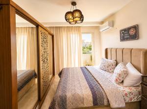a bedroom with a bed and a window at Luxury Seaside Villa Direct Pool Access, Private Garden & Rooftop Stella Heights Sidi Abdelrahman فيلا مميزه جدا في الساحل الشمالي ستيلا هايتس سيدي عبدالرحمن in El Alamein +23 photos