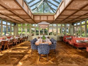 a dining room with tables and chairs and windows at Clandeboye Lodge Hotel in Bangor