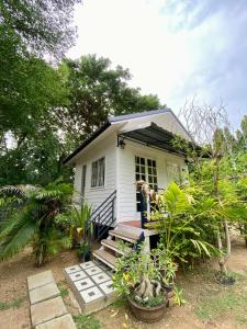 a small white house with people standing on the porch at Baan Suan Yensabai @Ayutthaya in Phra Nakhon Si Ayutthaya +24 photos