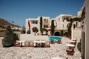 a patio with tables and chairs next to a pool at Proteas Hotel & Suites in Agios Prokopios +61 photos