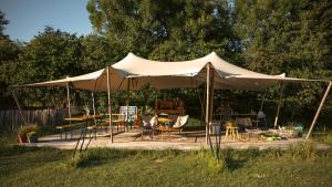 a white tent with chairs and tables in a yard at Wild Wild West Saloon in Paasloo