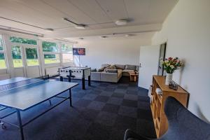 a living room with two ping pong tables and a couch at Danhostel Tønder in Tønder