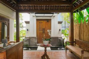 a porch with a wooden door and a bench at Sunset Loft Seminyak, Bali in Seminyak +53 photos