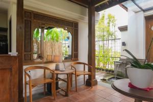 a dining room with a table and chairs and a window at Sunset Loft Seminyak, Bali in Seminyak