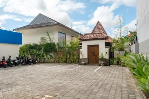 a house with motorcycles parked in a parking lot at Sunset Loft Seminyak, Bali in Seminyak