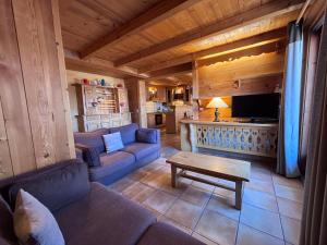 a living room with a couch and a table at Appartement Chez Marion in Notre-Dame-de-Bellecombe