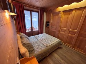 a small bedroom with a bed and a window at Appartement Chez Marion in Notre-Dame-de-Bellecombe