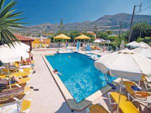 a swimming pool with chairs and umbrellas in a resort at Stalis Bay Villa in Stalís