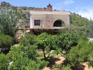 a house on a hill with trees in front of it at Stalis Bay Villa in Stalís