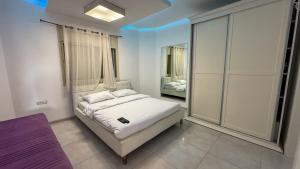 a bedroom with a white bed and a mirror at Liberty spa & suites - שלוש סוויטות ושתי ווילות מהממות עם בריכה פרטית in Manot +33 photos