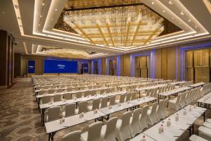 an empty banquet hall with white chairs and tables at Hilton Urumqi in Ürümqi +110 photos