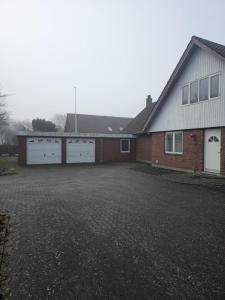 a house with two garage doors and a driveway at Glentevej 4 in Ringkøbing