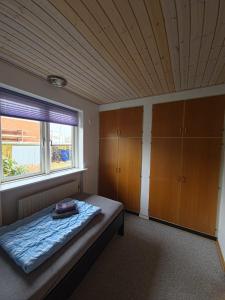 a bedroom with a bed with a wooden ceiling at Glentevej 4 in Ringkøbing