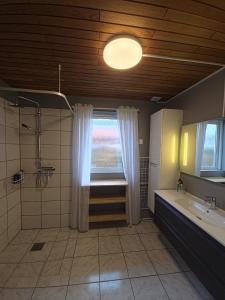 a bathroom with a shower and a sink and a window at Glentevej 4 in Ringkøbing