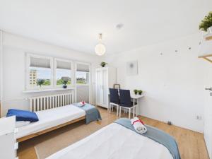 a room with two beds and a table at Comfort ROOM, Kochanowskiego 32 in Warsaw