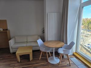 a living room with a table and chairs and a couch at Štrbské Pleso rezidencia Oliver - apartmán 16A in Štrbské Pleso