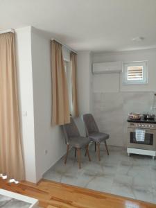 a kitchen with two chairs and a table and a stove at DM Apartman in Foča