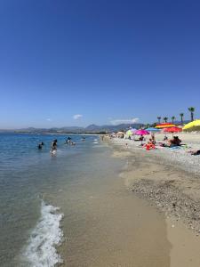 a group of people in the water at the beach at Suite la Ficara in Bovalino Marina