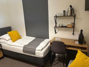 a bedroom with a bed and a desk and a table at Penzion U Kašpara in Lovosice
