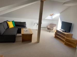 a living room with a couch and a tv at Hotel Zámeček na Čeladné in Čeladná
