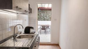 a kitchen with a sink and a window with a table at Casa Olmedina in Olmedo +5 photos