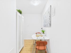 a white dining room with a white table and two chairs at Comfort ROOM, Kochanowskiego 32 in Warsaw