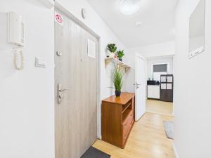 a hallway with a door and a dresser with a plant on it at Comfort ROOM, Kochanowskiego 32 in Warsaw +22 photos