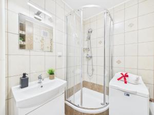 a white bathroom with a shower and a sink at Comfort ROOM, Kochanowskiego 32 in Warsaw