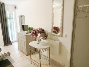 a white table with a vase of flowers on it at studio stella in Sospel