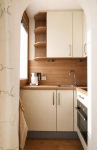 a kitchen with white cabinets and a sink at Stein 35 with Kitzstainhorn view in Kaprun